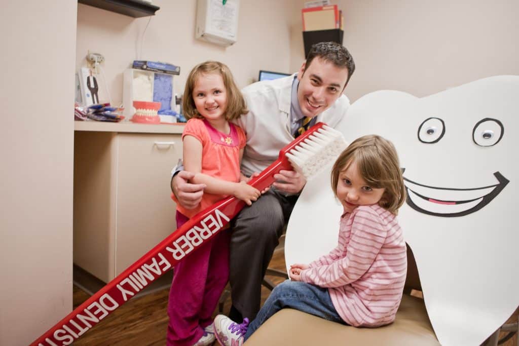 Dr. Mike Verber with his kids in the dental office