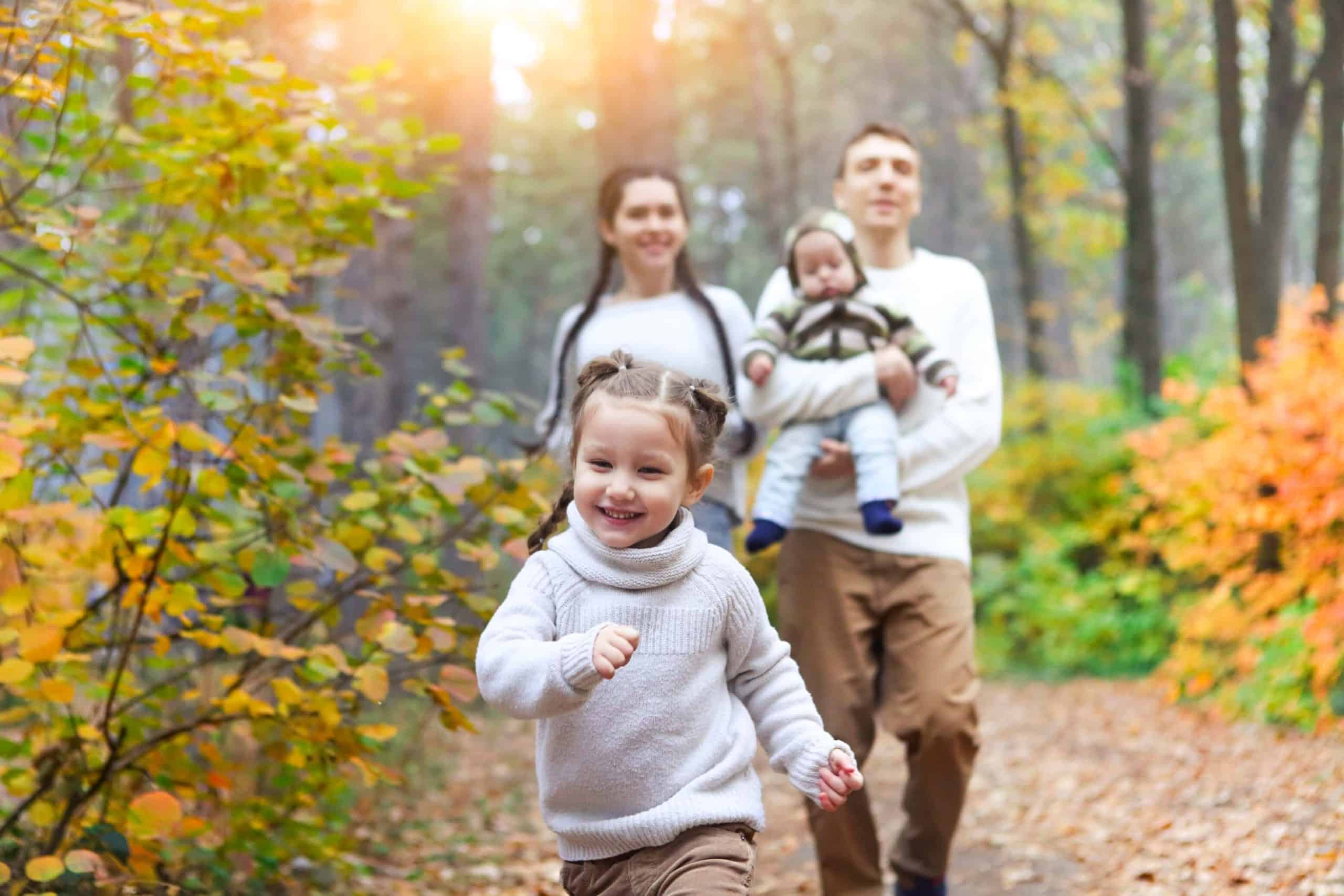 a smiling white family in the woods
